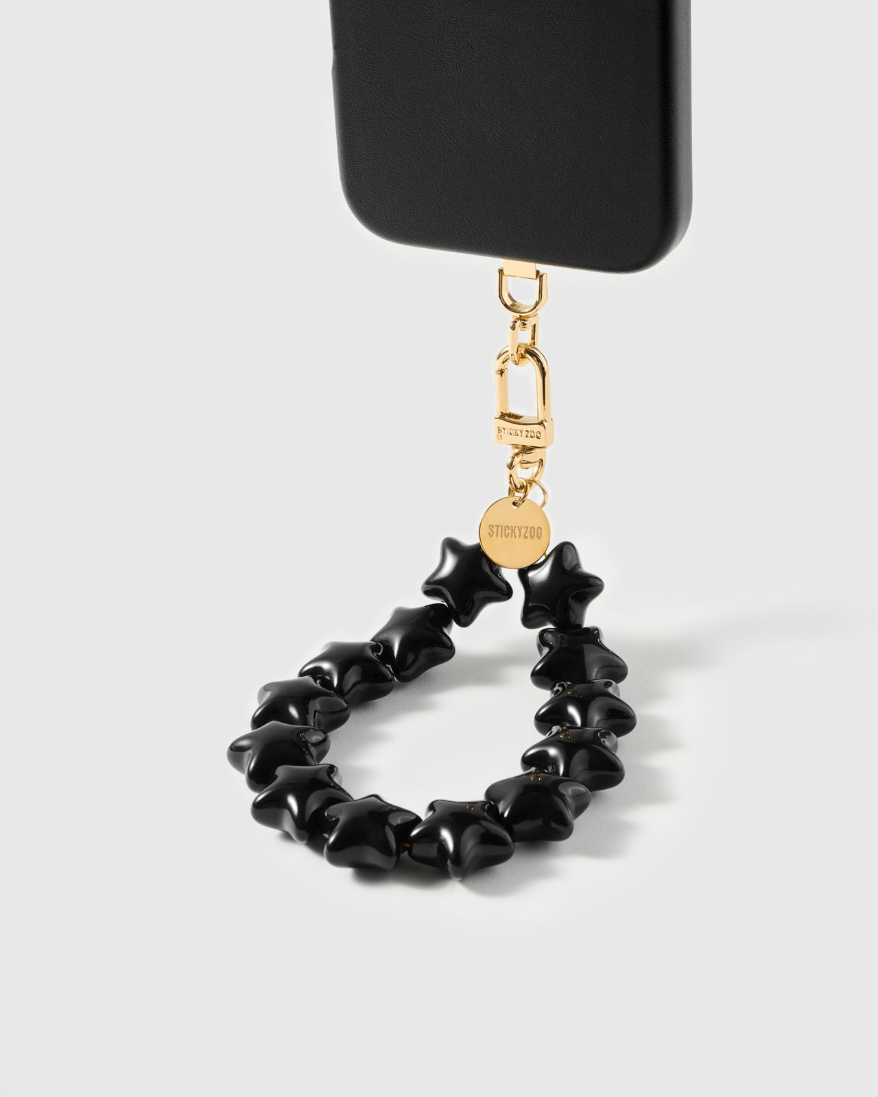 Glossy noir star bead loop swinging from phone case showing wristlet drape — Loved by Thousands