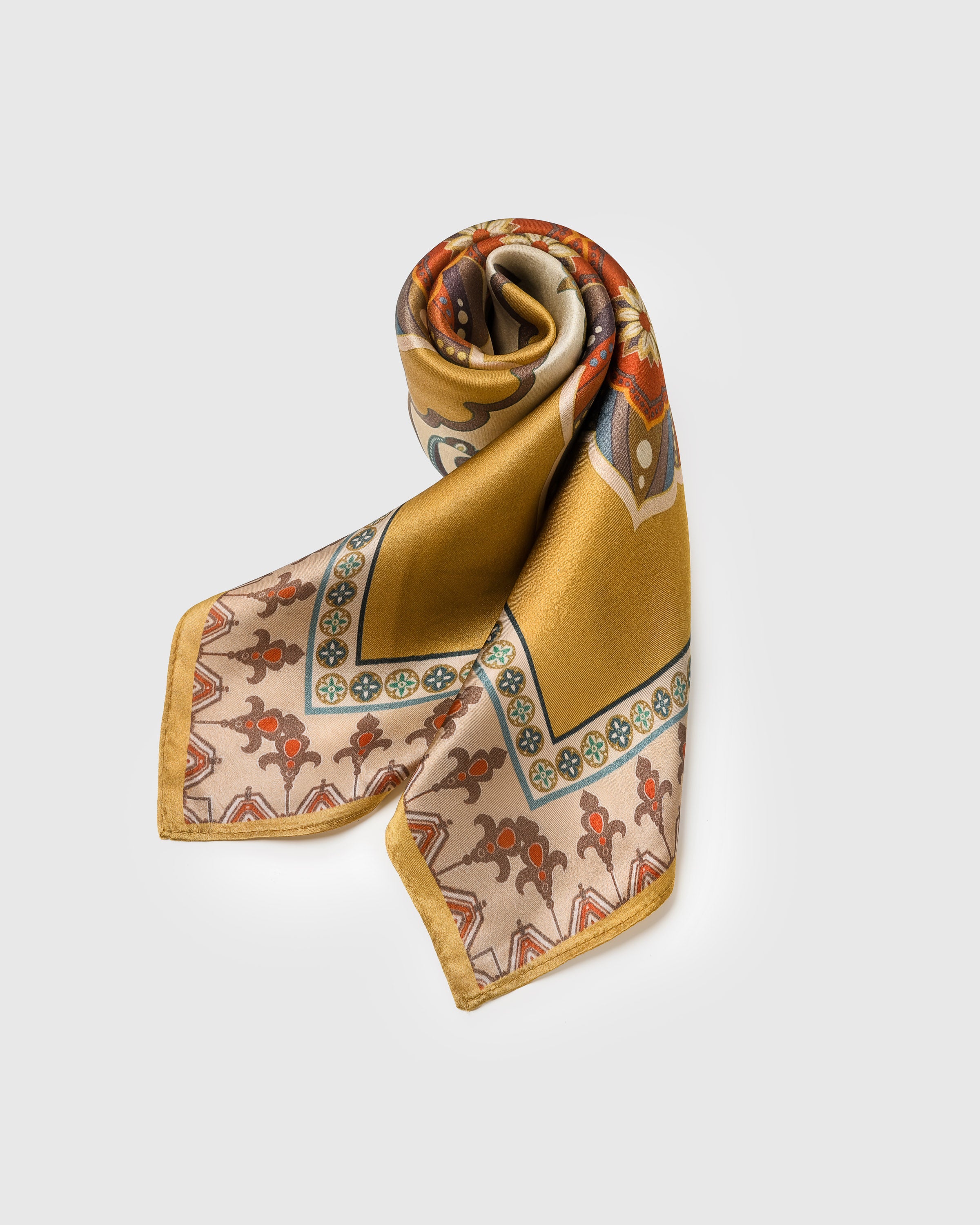 Saffron silk scarf folded into a triangular drape showing the medallion field and the taupe rosette border
```