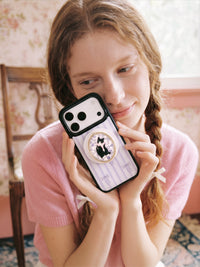 STICKYZOO framed tuxedo cat phone case held up close with the oval portrait medallion facing out