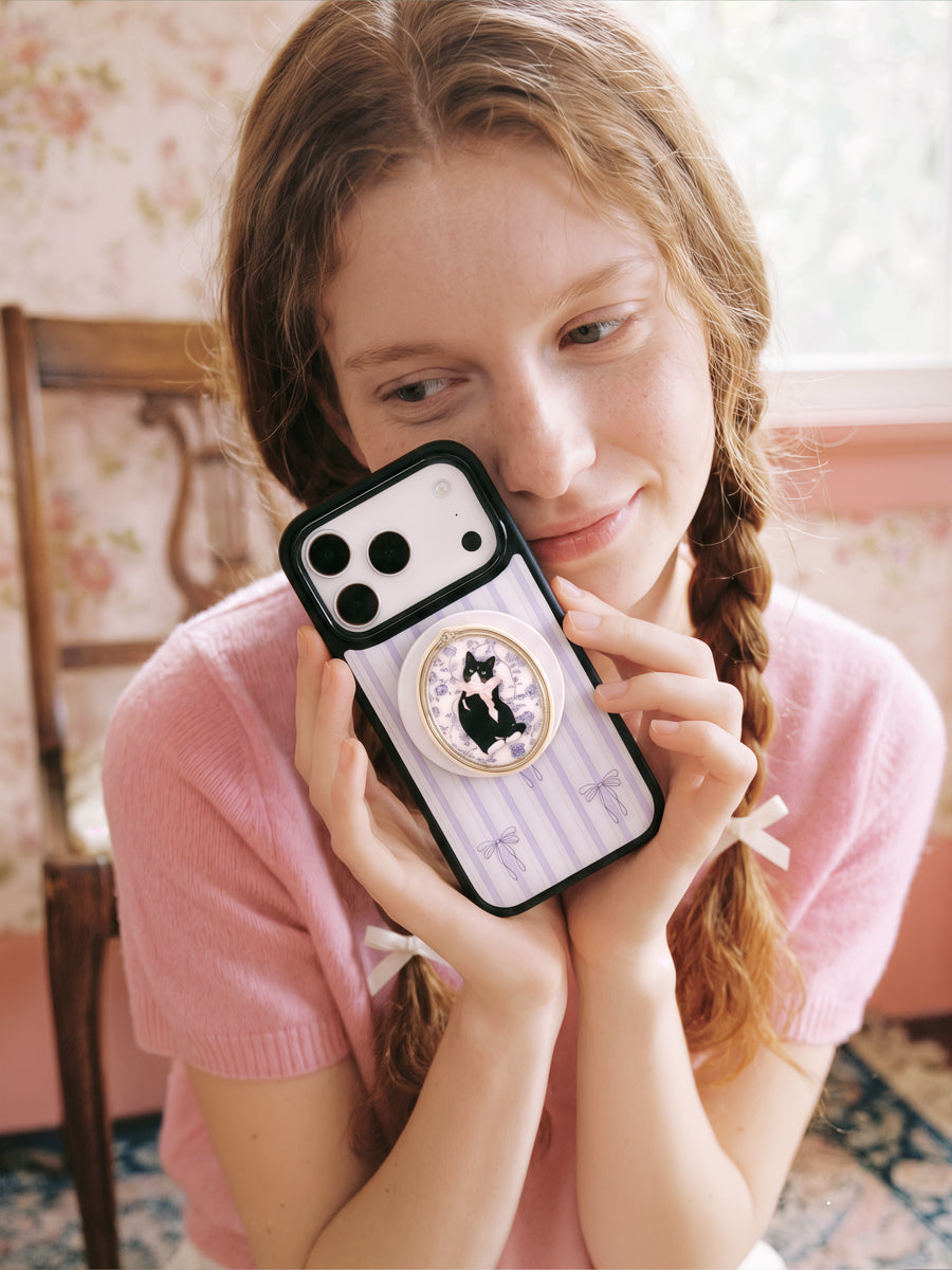 STICKYZOO framed tuxedo cat phone case held up close with the oval portrait medallion facing out
