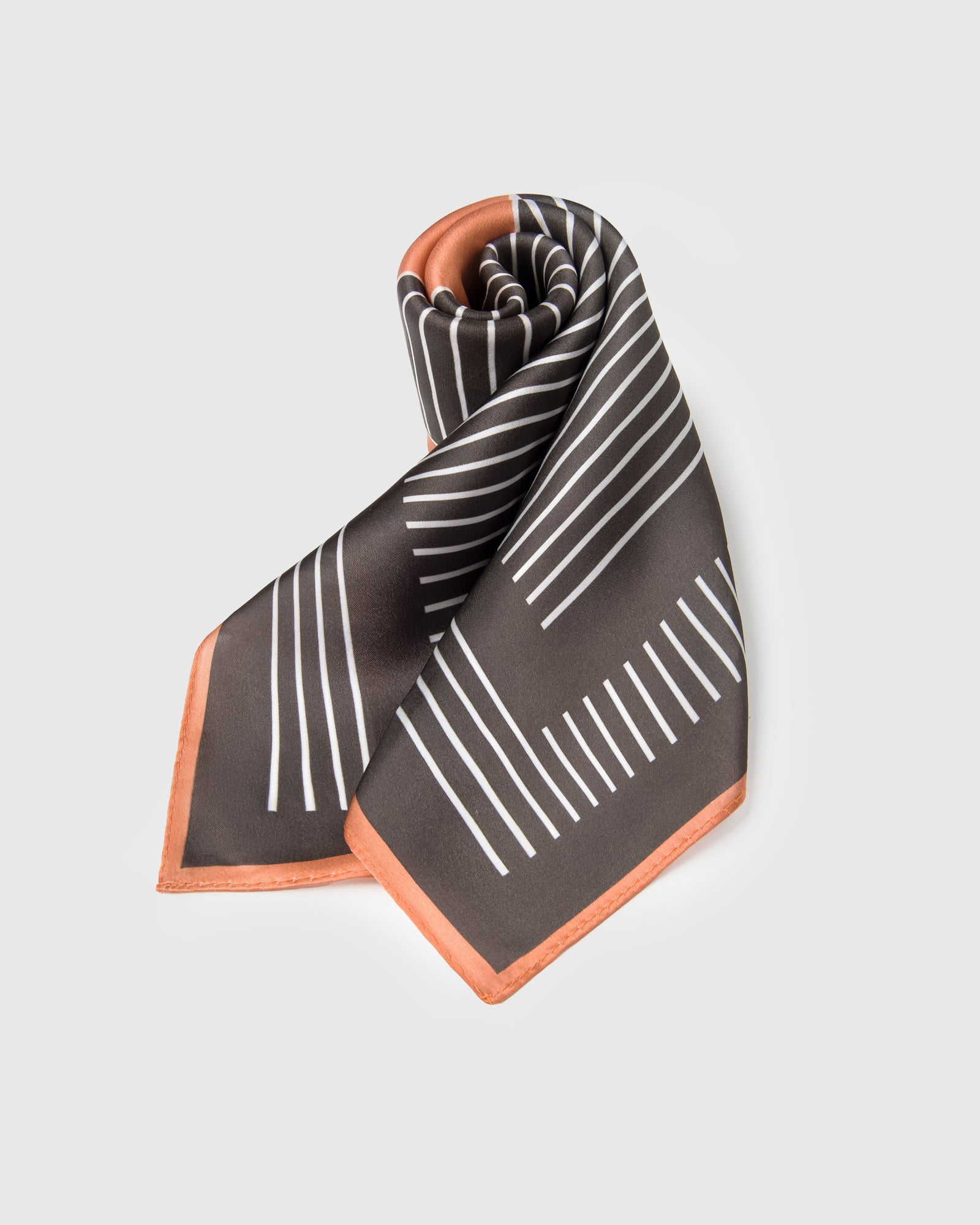 Op-art diamond silk scarf with concentric ivory stripes on charcoal and a tilted terracotta diamond at center
```
