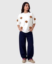 Model in white Poodle Parade T-Shirt with hands in pockets showing relaxed silhouette