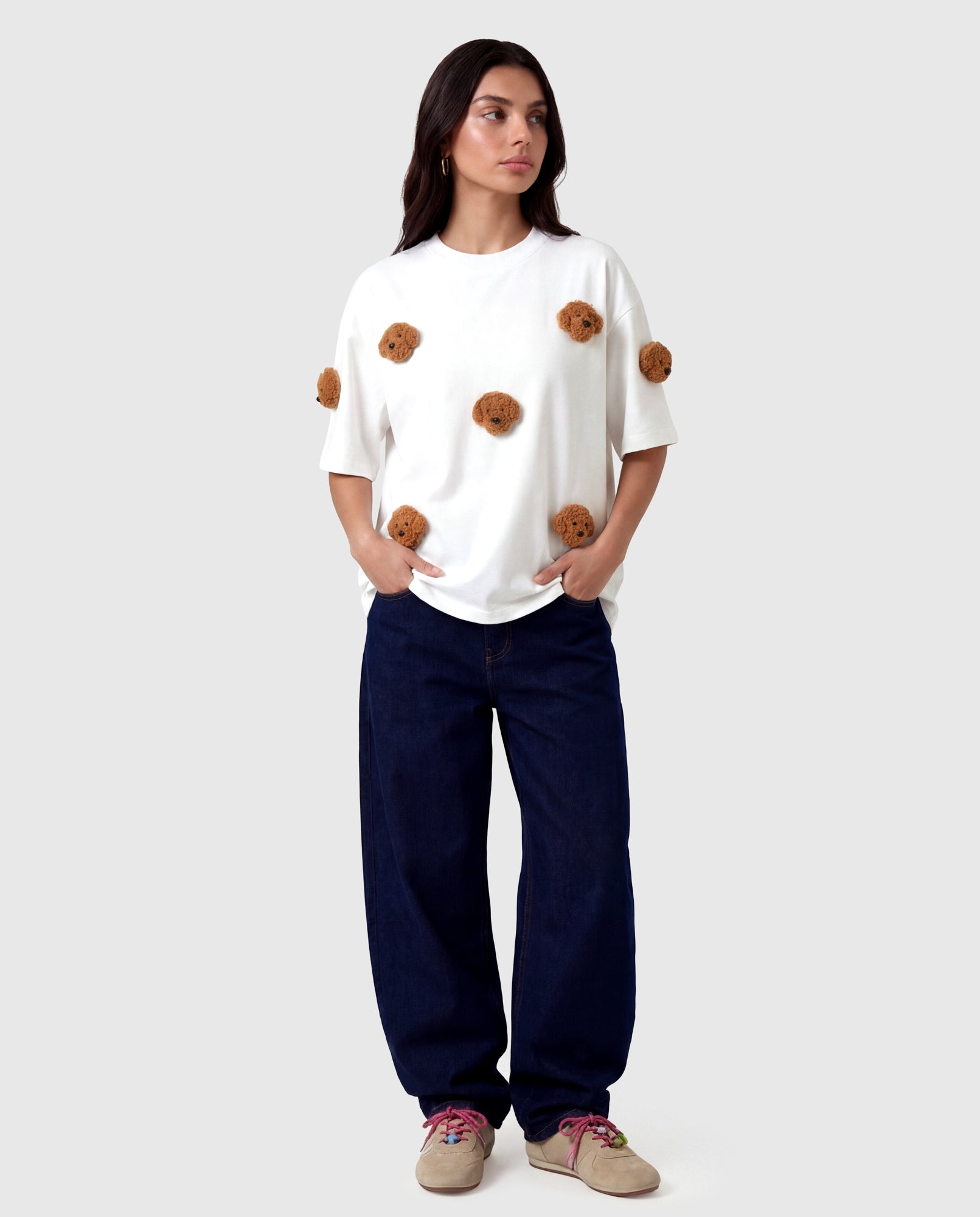 Model in white Poodle Parade T-Shirt with hands in pockets showing relaxed silhouette