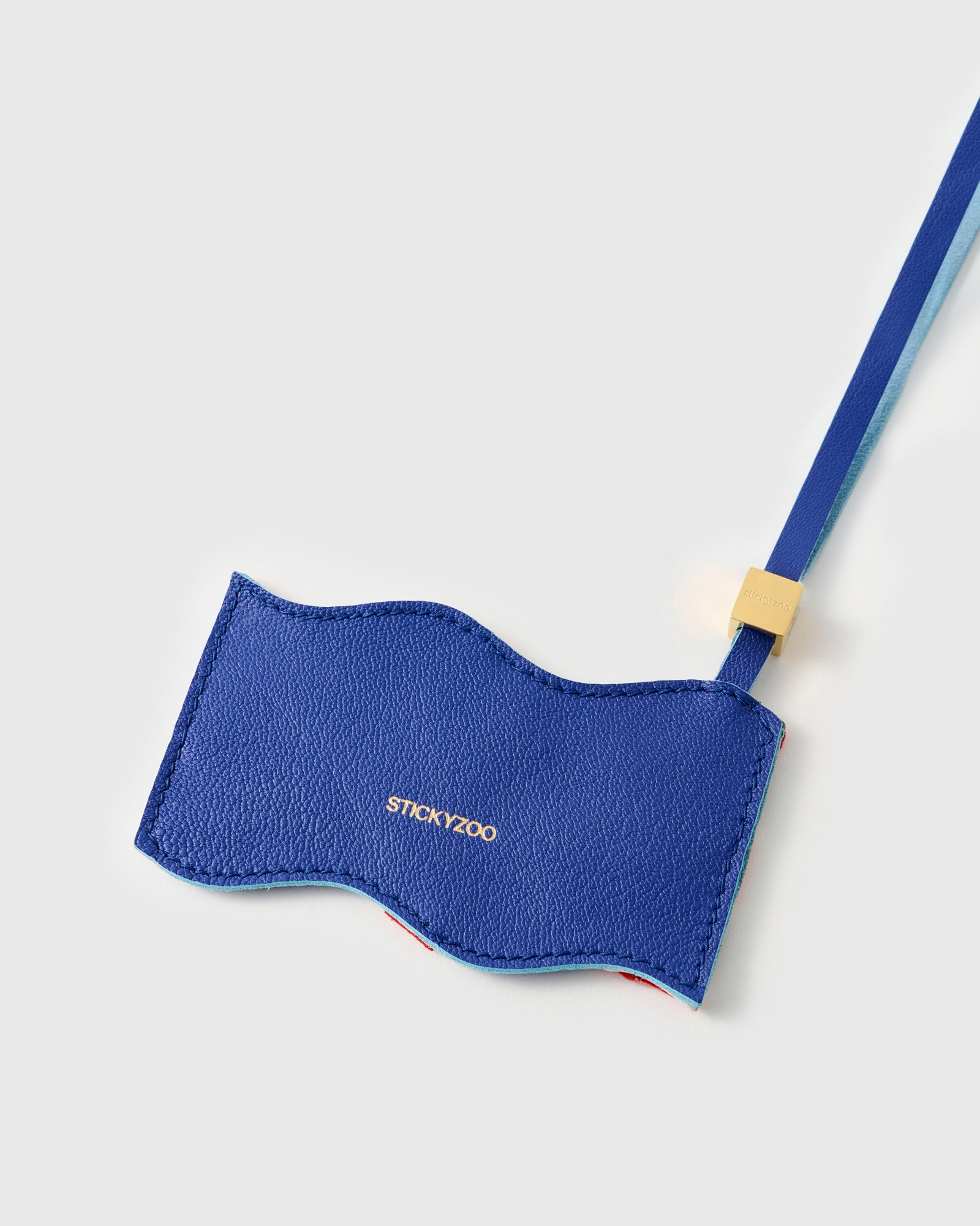 Back panel of Union Jack charm in cobalt blue French Alran leather with gold debossed STICKYZOO branding