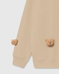 Close-up of plush bear face appliques on cream cotton showing soft tonal detail and 3D texture