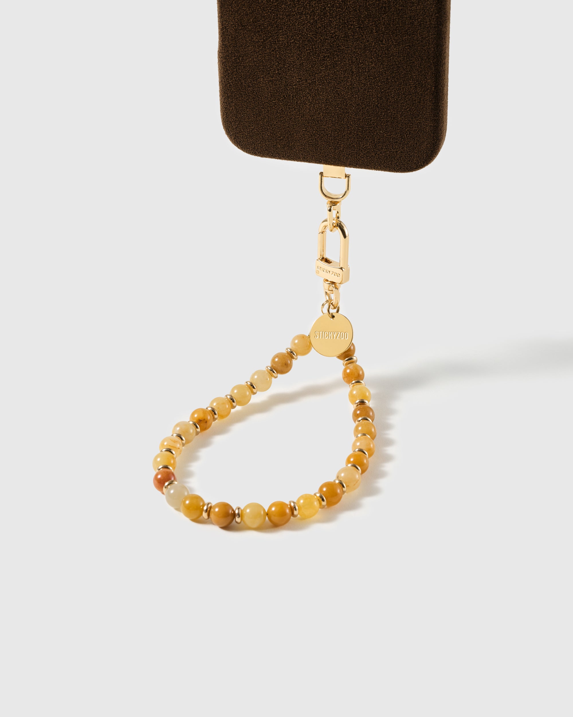 Beaded stone phone strap attached to a phone case with the gold clasp visible, showing universal fit with any case