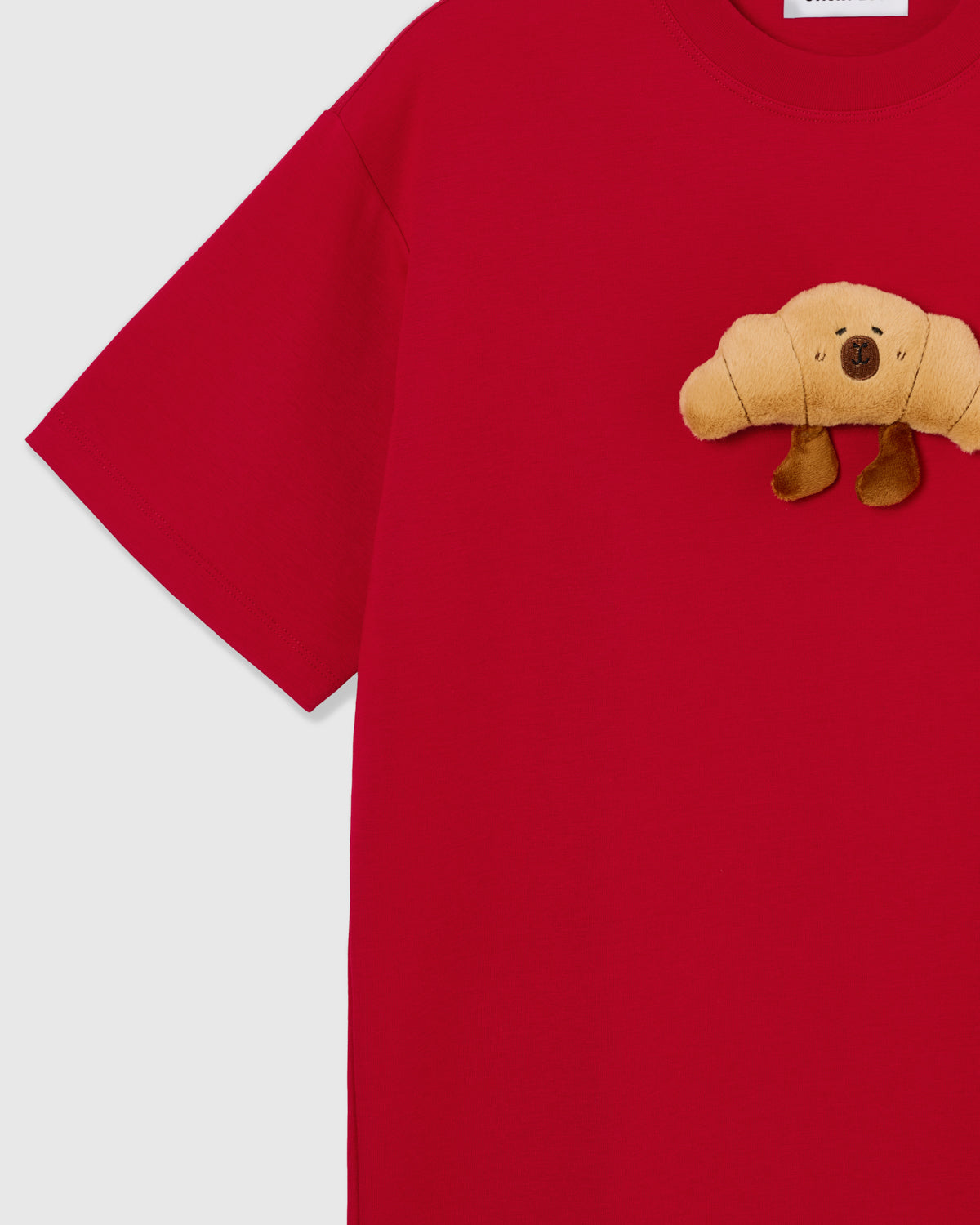 Detail of sleeve and side on STICKYZOO red Runaway Croissant T-Shirt showing boxy construction