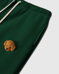 Close-up of plush poodle applique near pocket on forest green 350gsm cotton showing 3D texture
