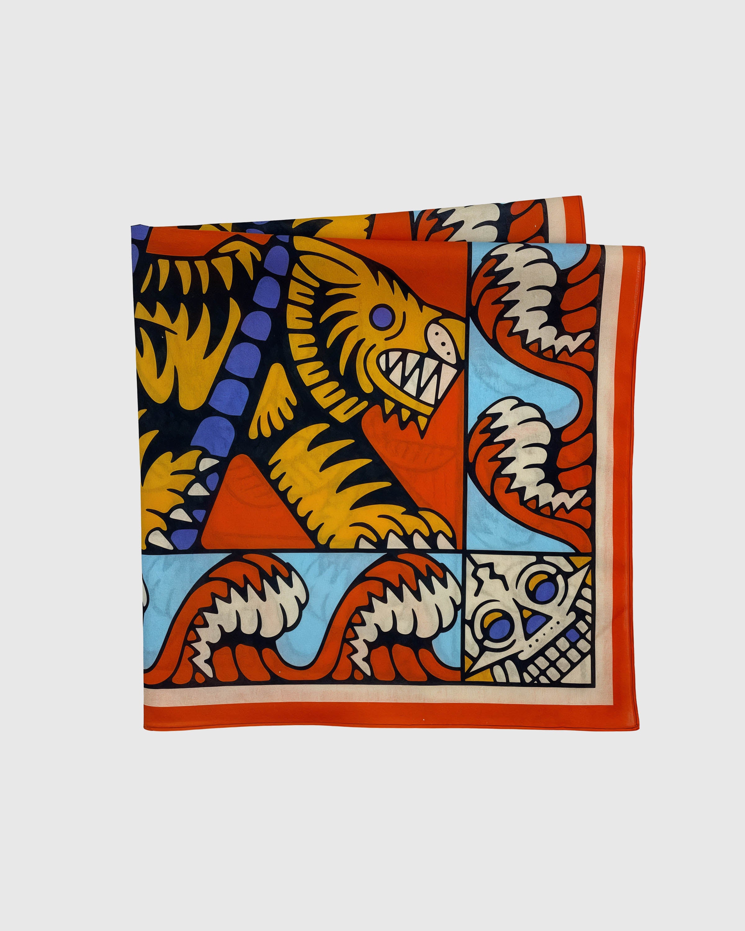 Folded tiger silk scarf showing the serrated wave border and the corner mask motif