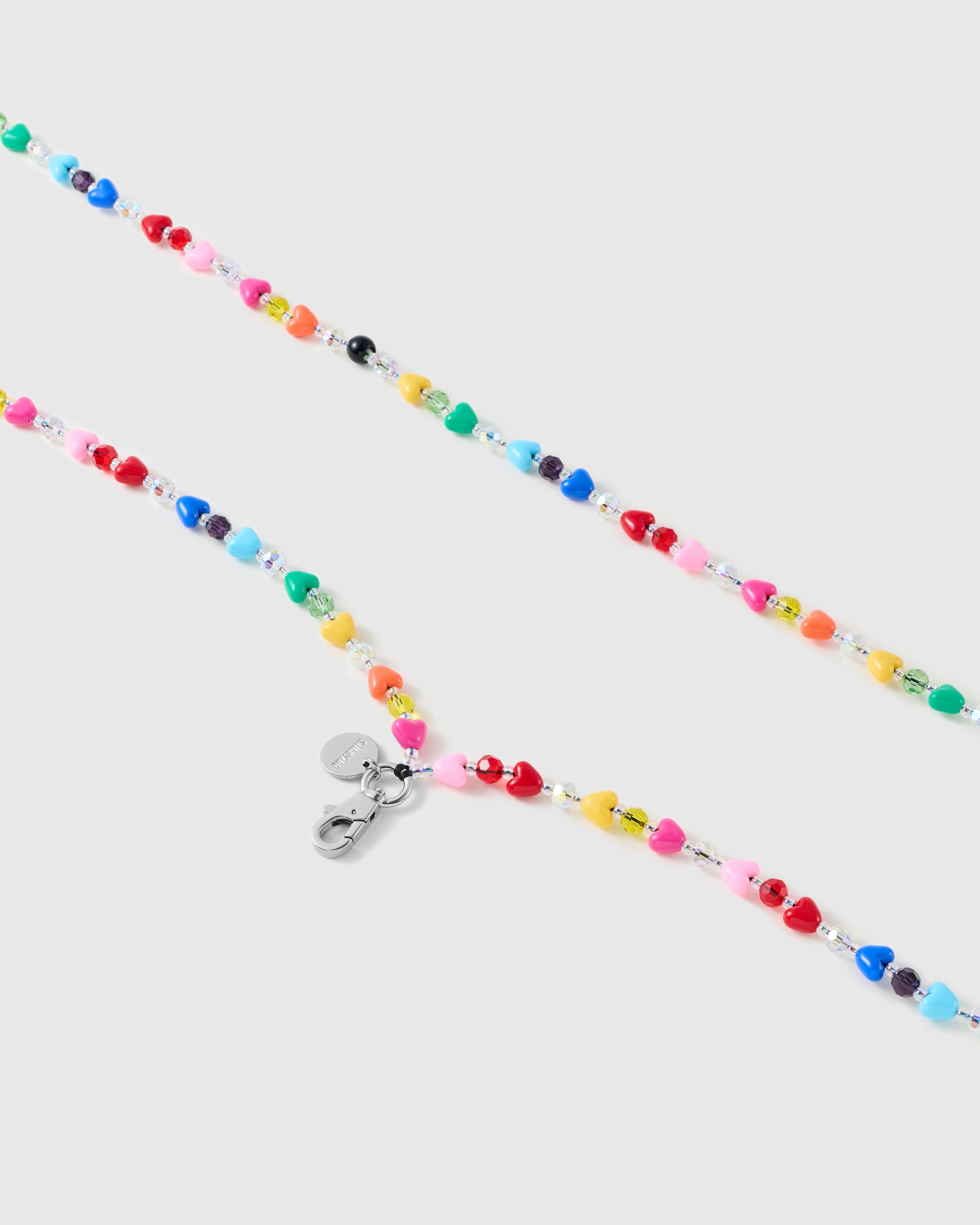 Close-up of the silver-tone lobster clasp and engraved round disc with glossy multicolour heart beads and clear and coloured faceted spacers.