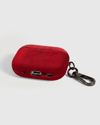Back view of red Alcantara case showing USB-C port, speaker cutouts, and metal carabiner