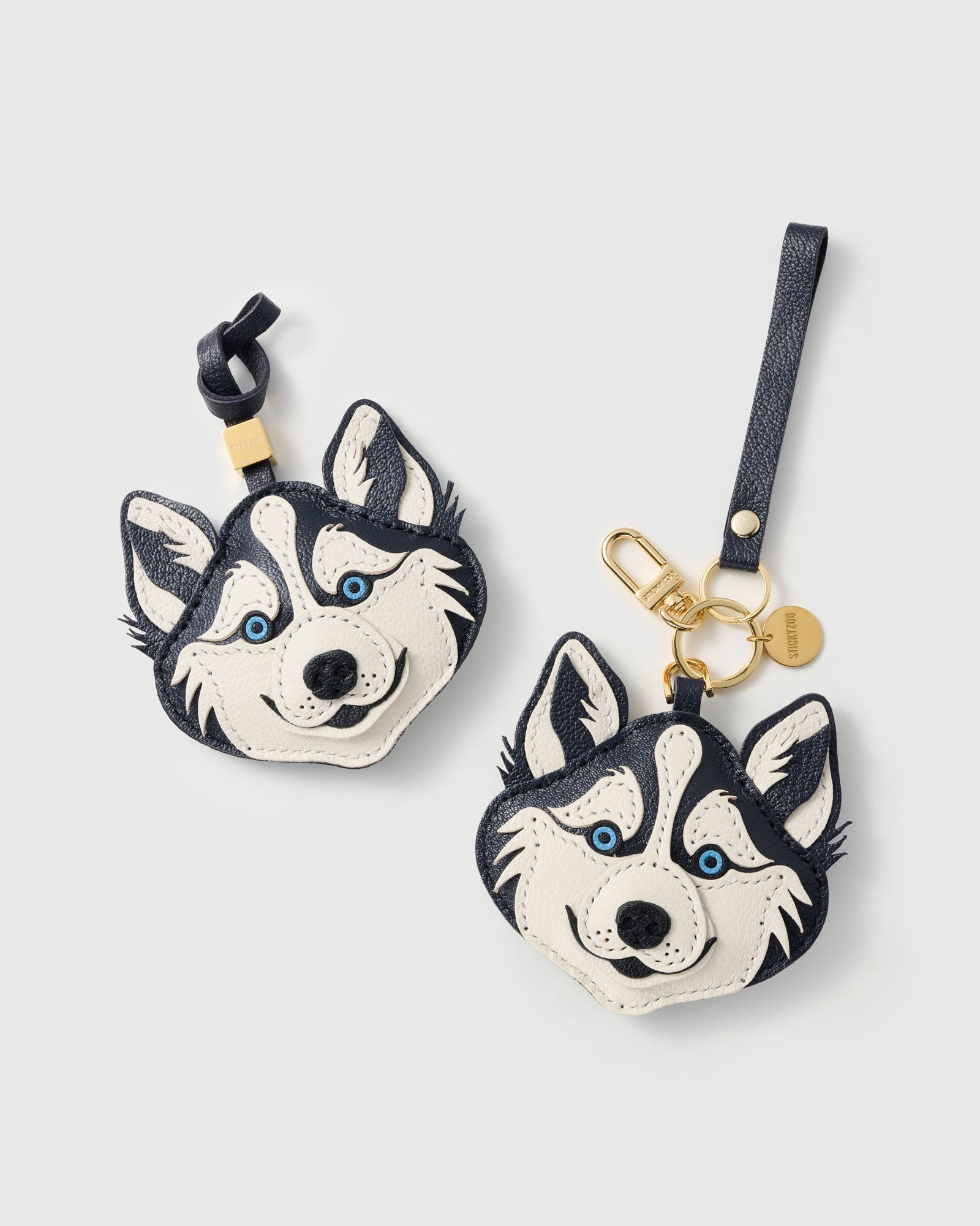{{Dual attachment included}} Both attachment styles — leather strap loop and 18K gold-plated keychain clip with STICKYZOO coin