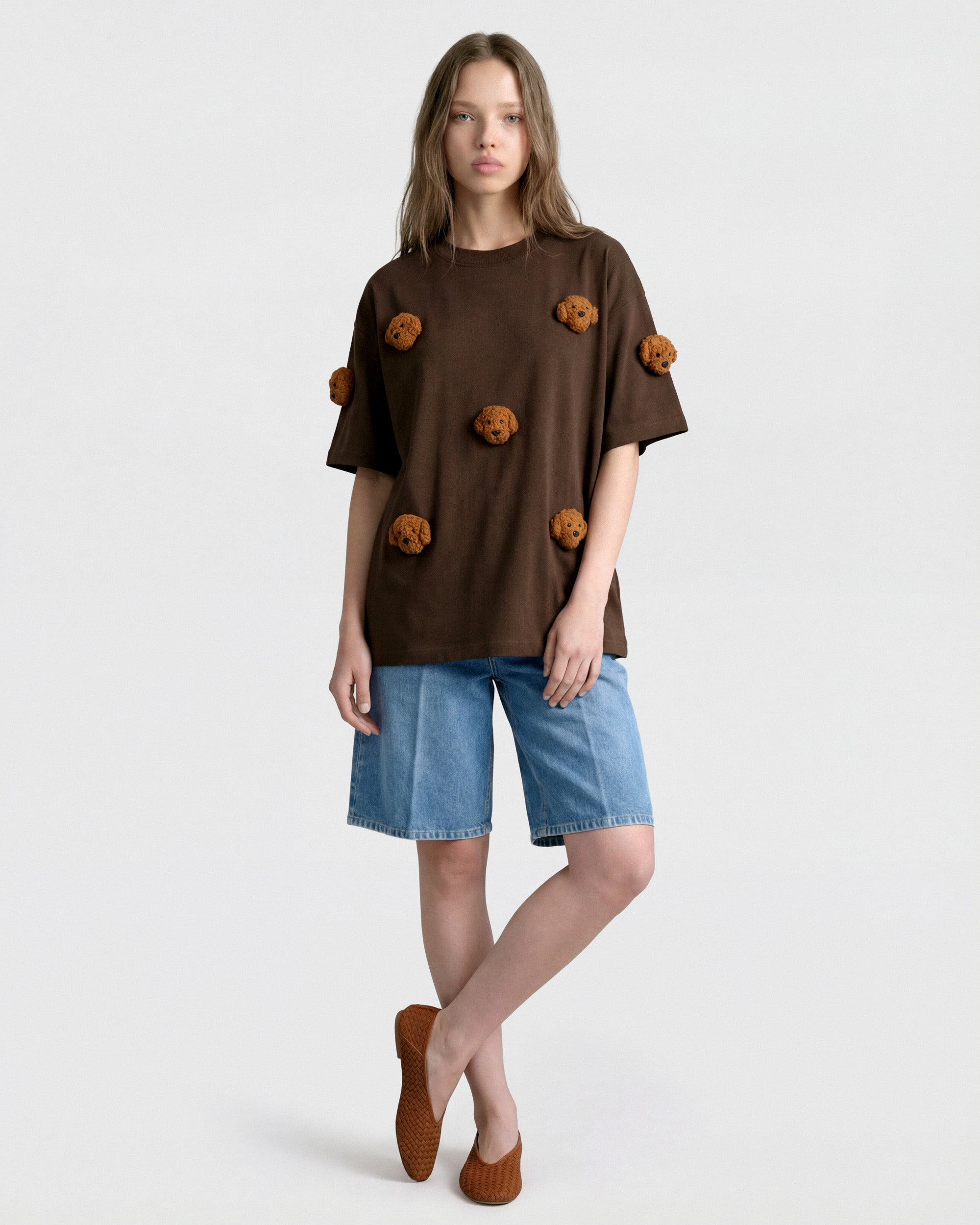 {{Relaxed oversized fit}} Model in brown Poodle Parade T-Shirt front view showing all seven plush poodle appliques