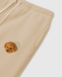 Close-up of plush poodle applique near pocket on cream 350gsm cotton showing 3D texture