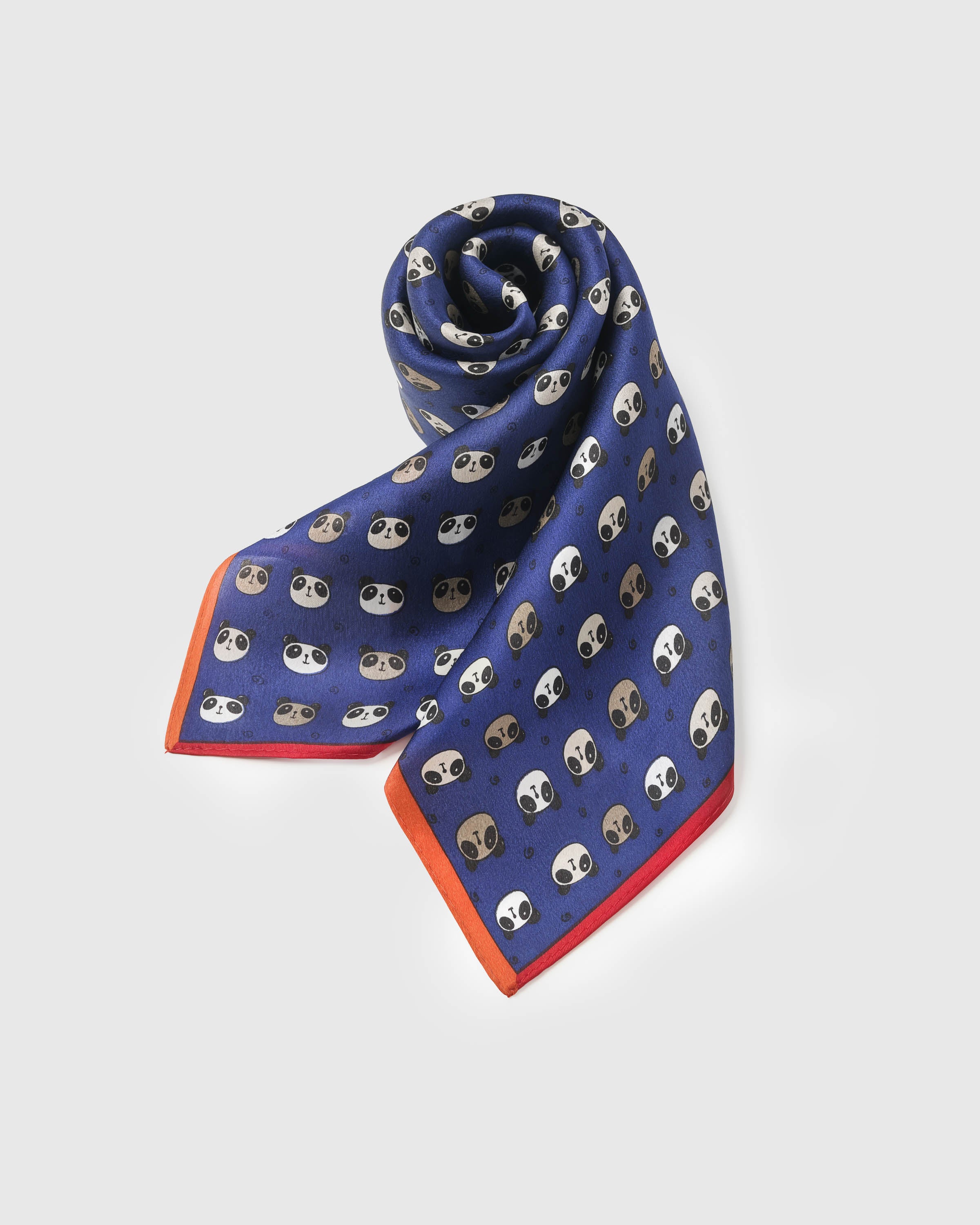 Rolled panda silk scarf showing the soft drape of the silk and the orange border framing the navy print
```