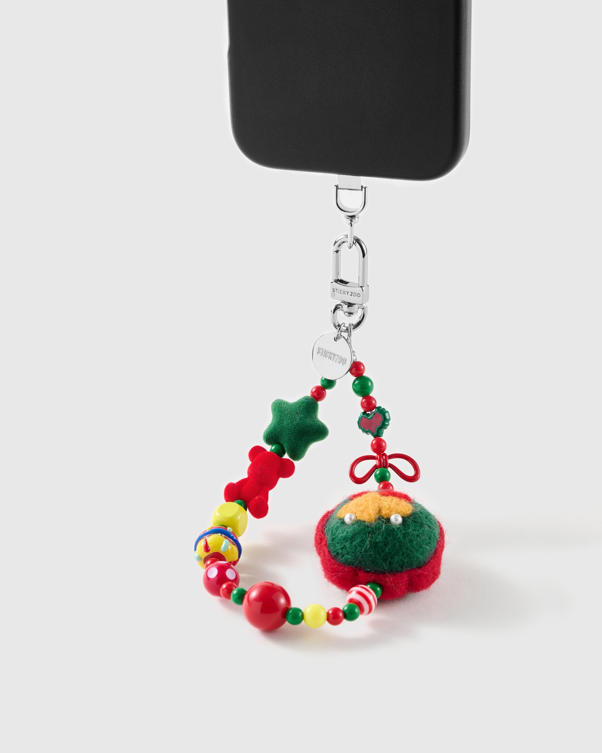 Jingle Wreath wrist strap clipped to a black phone case for hands-free carry