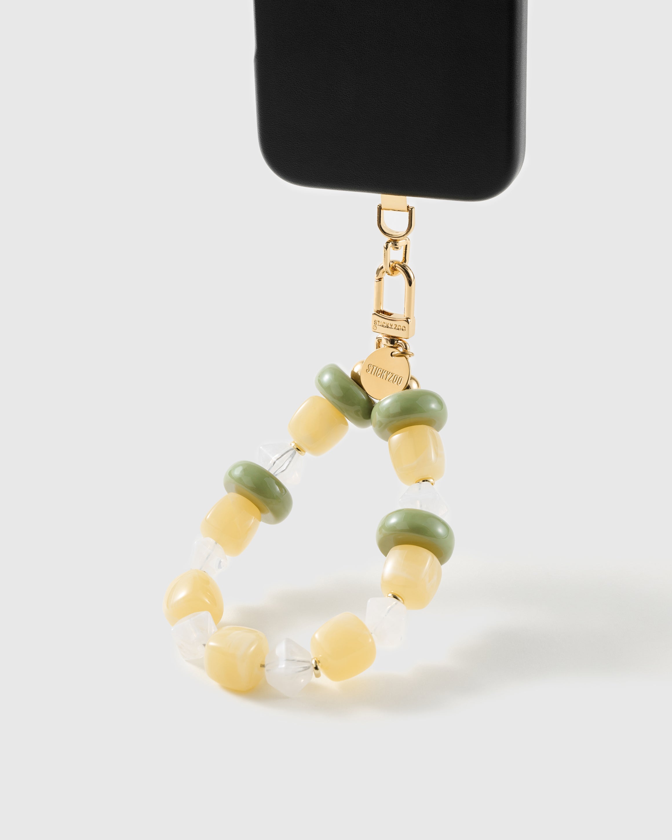 Lemon-lime beaded wrist strap clipped to a black phone case for hands-free carry