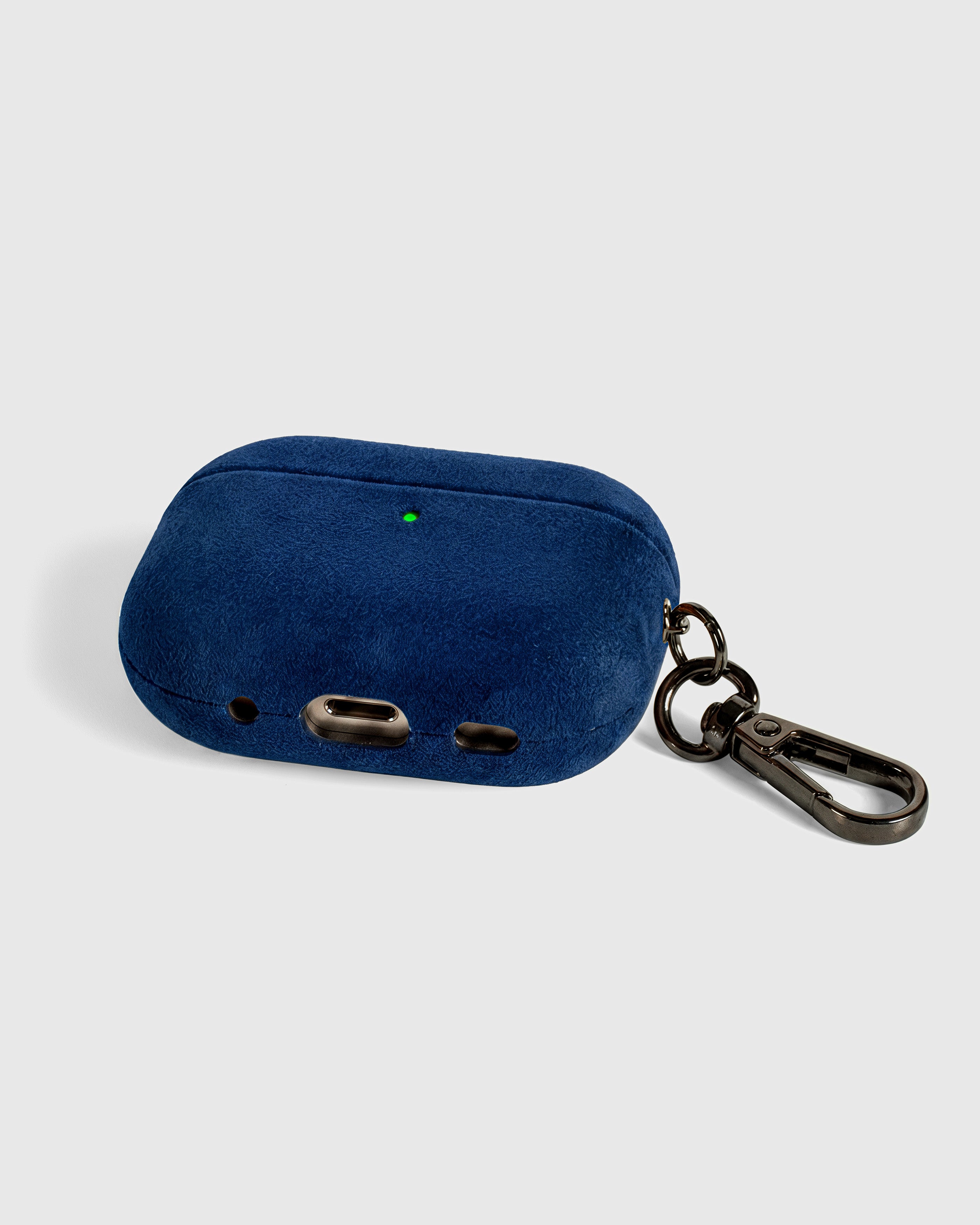 {{Built to last, not fade.}} Back view of deep navy Alcantara case showing USB-C port, speaker cutouts, and metal carabiner