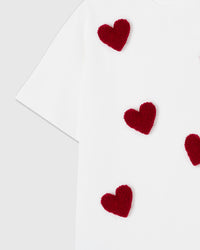 Close-up of individual plush heart showing soft textured burgundy fabric and hand-stitched attachment
