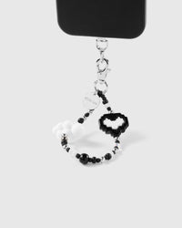 Noir heart cloud phone strap hanging from black phone case showing wrist carry