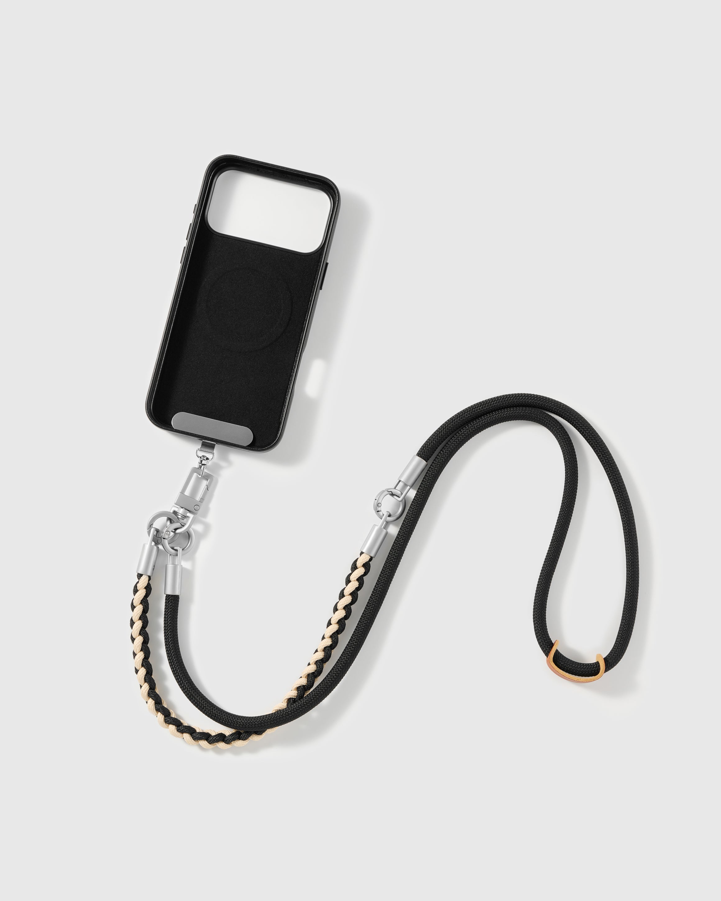 STICKYZOO cross-body phone strap laid flat beside a phone case it attaches to