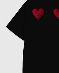 Detail of plush heart applique showing dimensional depth on black cotton