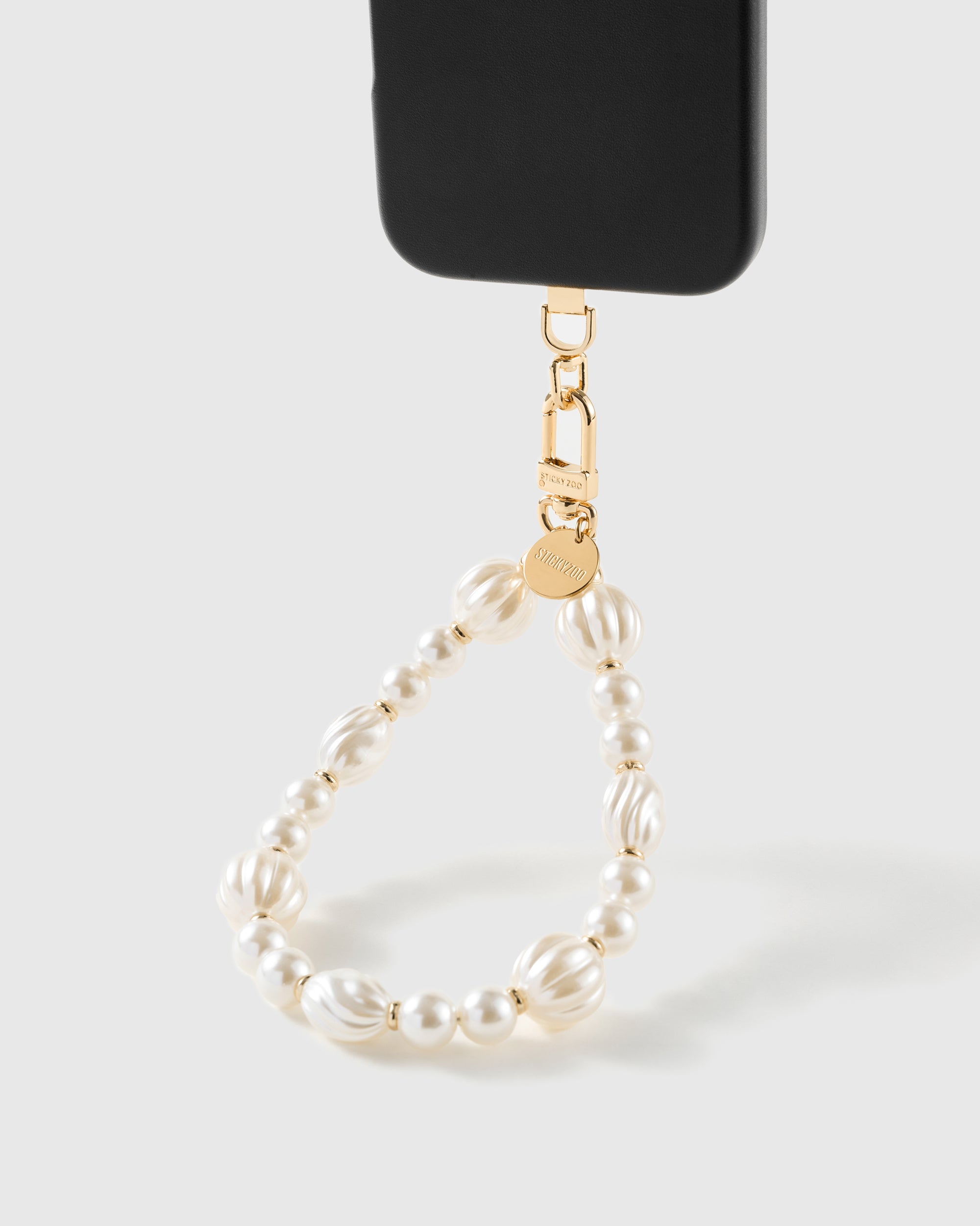 Ivory pearl-style beaded wrist strap attached to a phone case with a gold clasp, universal fit for any case