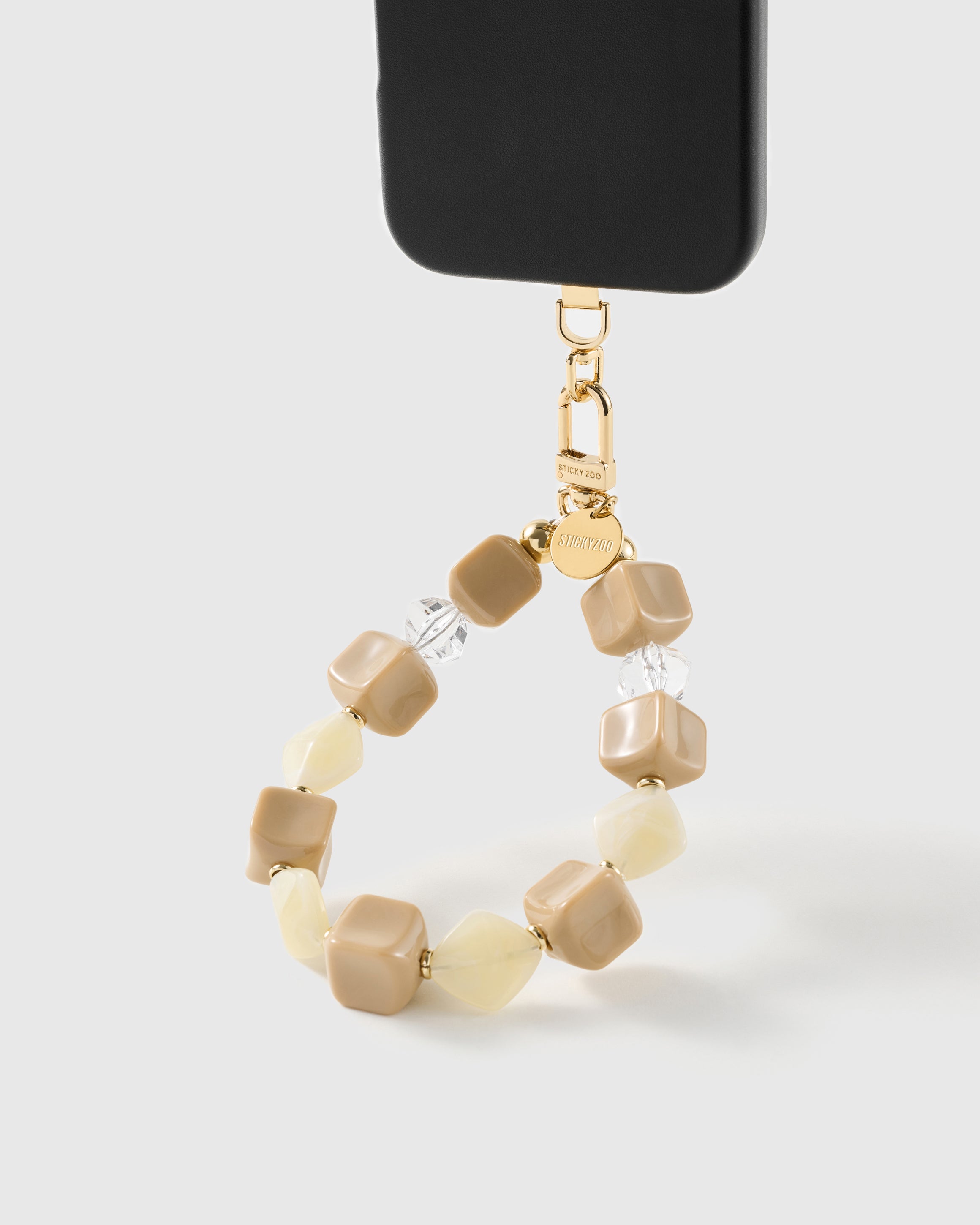 Latte marbled bead wrist strap clipped to a black phone case for hands-free carry