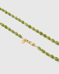 Close-up of olive-green polished resin nugget beads with a soft cloudy swirl, hand-assembled onto an 18K gold-plated cross-body phone strap clasp