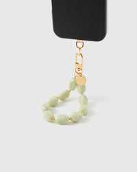 Sage agate phone strap hanging from black phone case showing soft green marbled stone beads