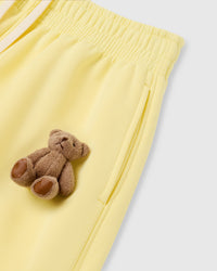 Close-up of plush bear applique on lemon heavyweight fleece showing individually sewn construction with embroidered detail