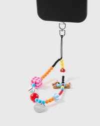 Clown dog phone strap hanging from black phone case showing wrist carry functionality