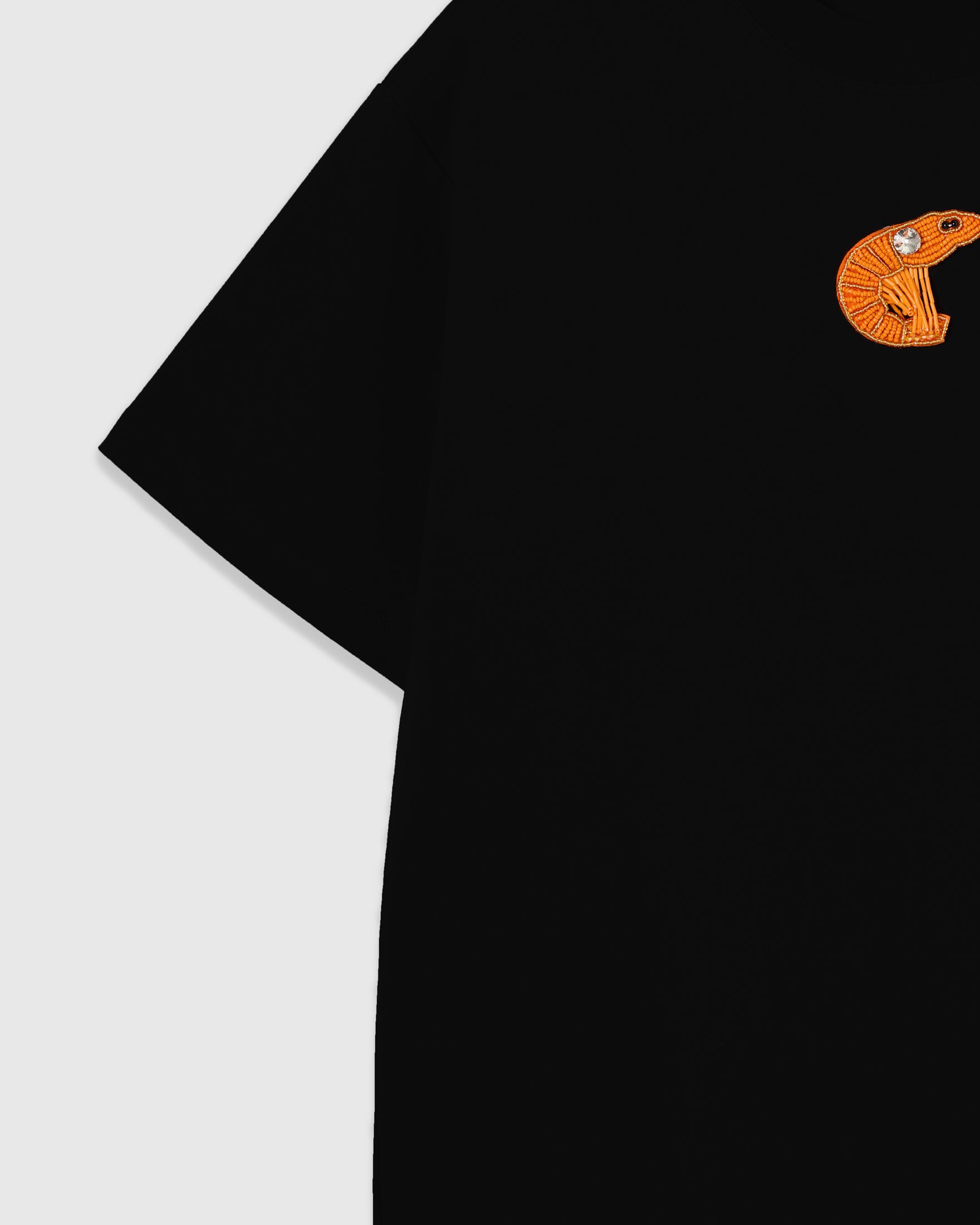 Dropped-shoulder sleeve and chest on the black 230gsm cotton tee with the beaded shrimp appliqué in frame