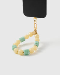 Butter jade orbit phone strap hanging from black phone case showing wrist carry