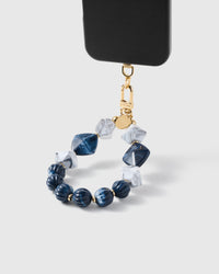 Sapphire marble cluster strap hanging from black phone case showing deep blue and white beads
