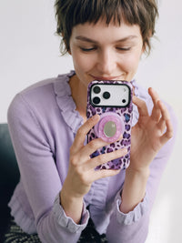 The STICKYZOO violet leopard phone case held up with the mirror pop-grip facing out for a quick glance