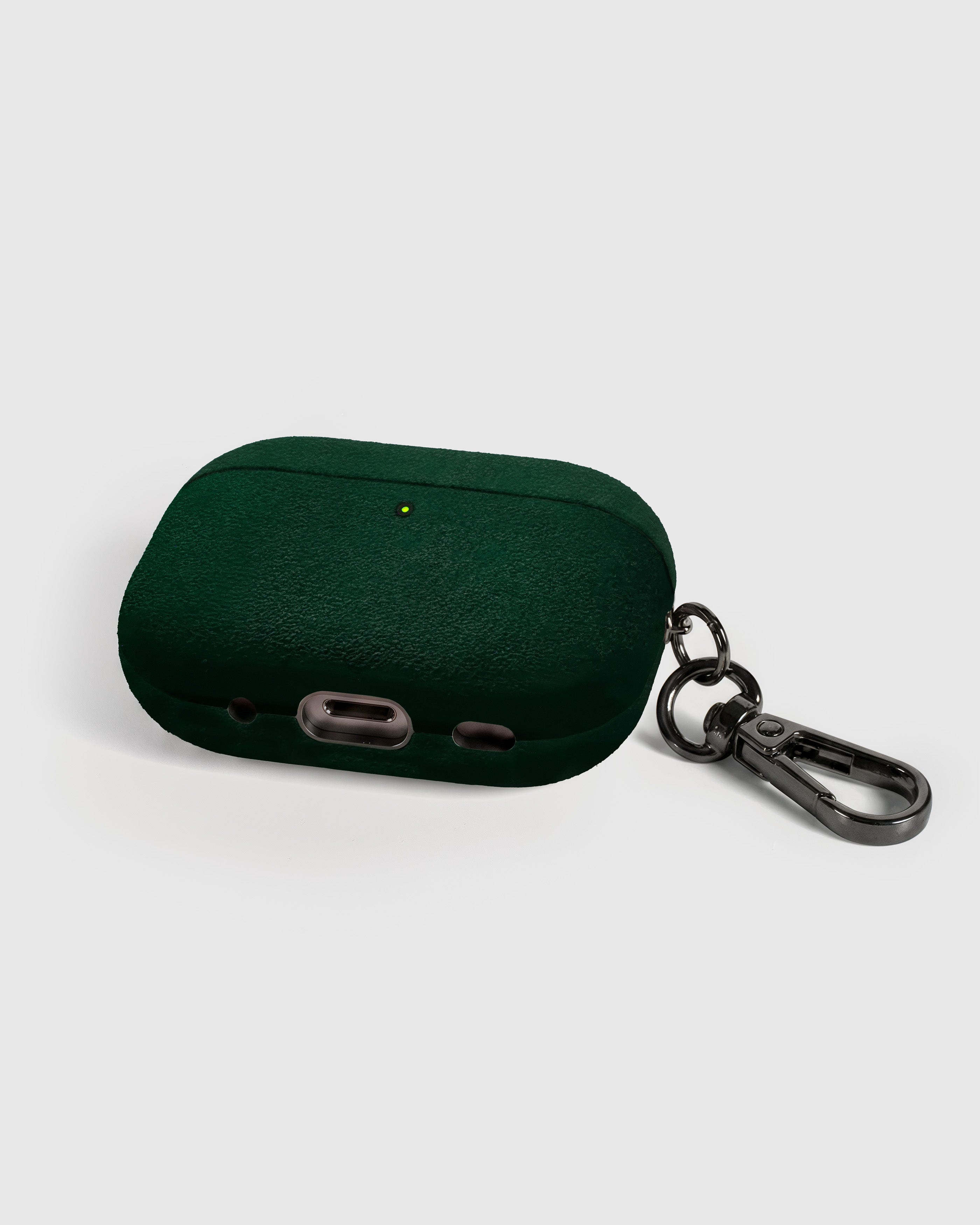 Back view of forest green Alcantara case showing USB-C port, speaker cutouts, and metal carabiner