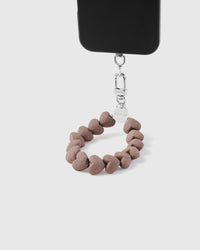 Phone strap worn on wrist showing hands-free everyday carry with heart beads