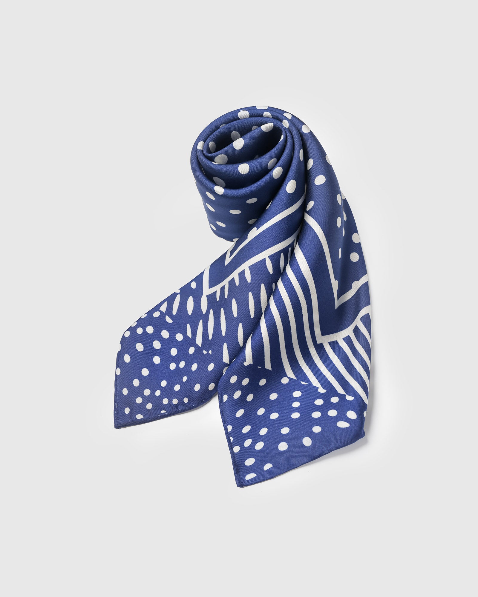 Cobalt stardust silk scarf rolled to show the soft drape and ivory hand-drawn print
```