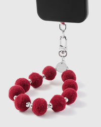 Close-up of crimson plush pom-pom beads showing deep berry color and silver spacers