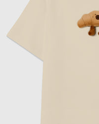 Detail of sleeve and side on STICKYZOO beige Runaway Croissant T-Shirt showing boxy construction