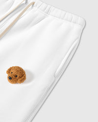 Close-up of plush poodle applique near pocket on white 350gsm cotton showing 3D texture