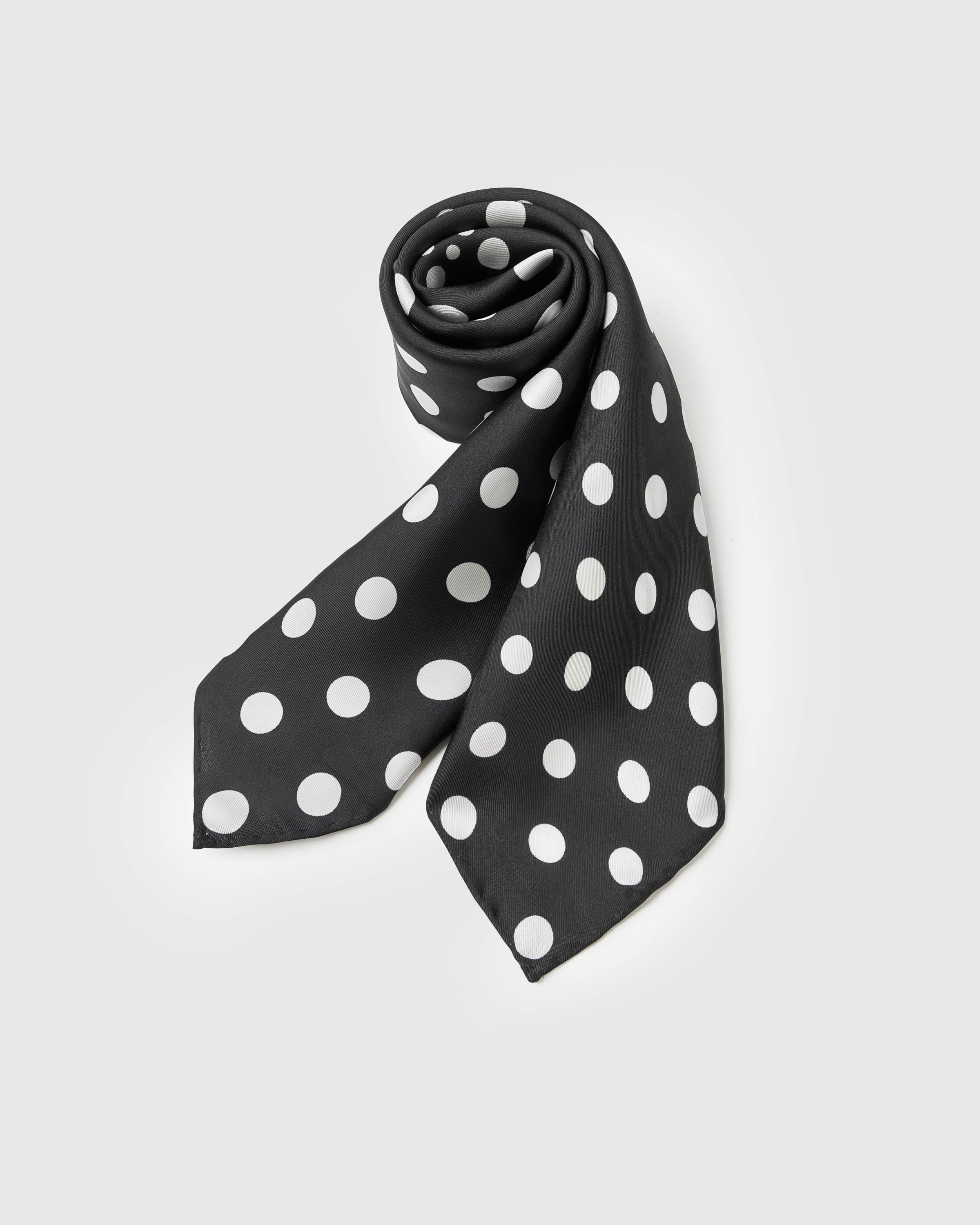 Rolled polka silk scarf showing the soft drape of the silk and the way the dot scales play across the fold
```