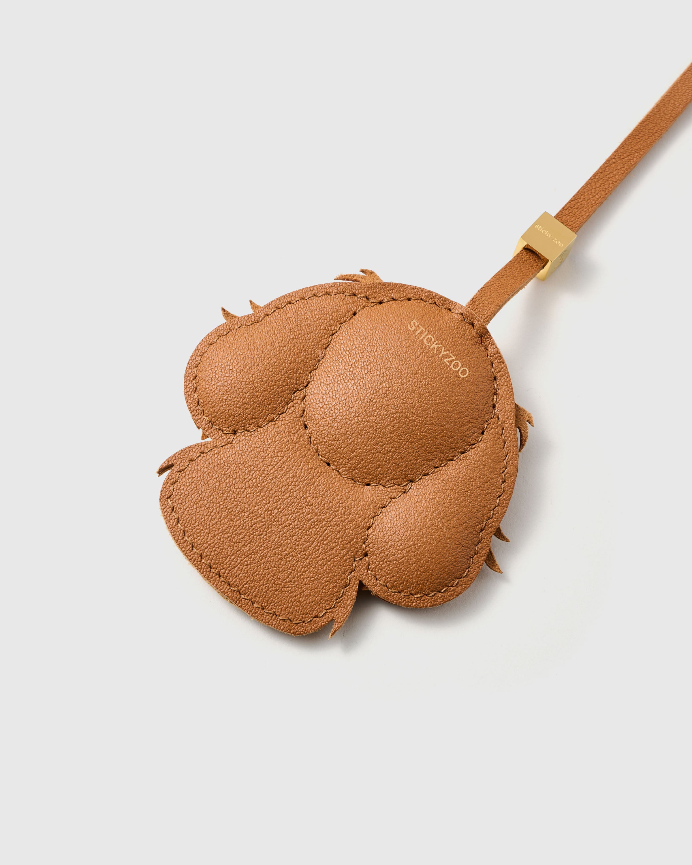 {{Finished on both sides.}} Smooth French Alran goatskin back with gold STICKYZOO debossing — 72 hours of hand-stitching holds every panel.