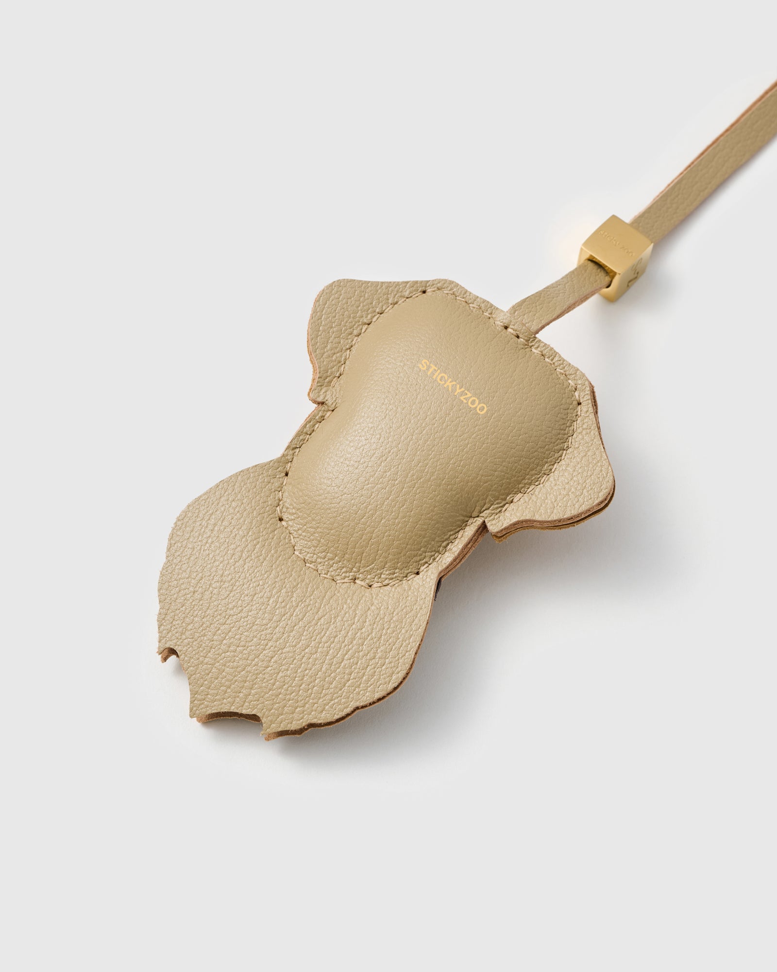 {{Finished on both sides.}} Back view of the Labrador Retriever charm — smooth sand French Alran goatskin with gold STICKYZOO embossing. Clean finish.