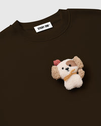 Close-up of plush puppy with pink beret and golden scarf on STICKYZOO Cardinal Puppy Sweatshirt showing dimensional hand-stitched detail