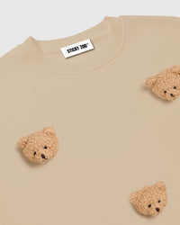 Flat-lay of cream Sticky Bear Sweatshirt with all six plush bears visible on premium cotton