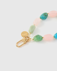Close-up of gold-plated clasp and engraved STICKYZOO charm disc with multi-color marble beads