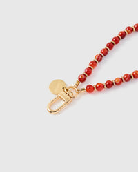 Close-up of natural scarlet stone beads showing warm veining and color variation