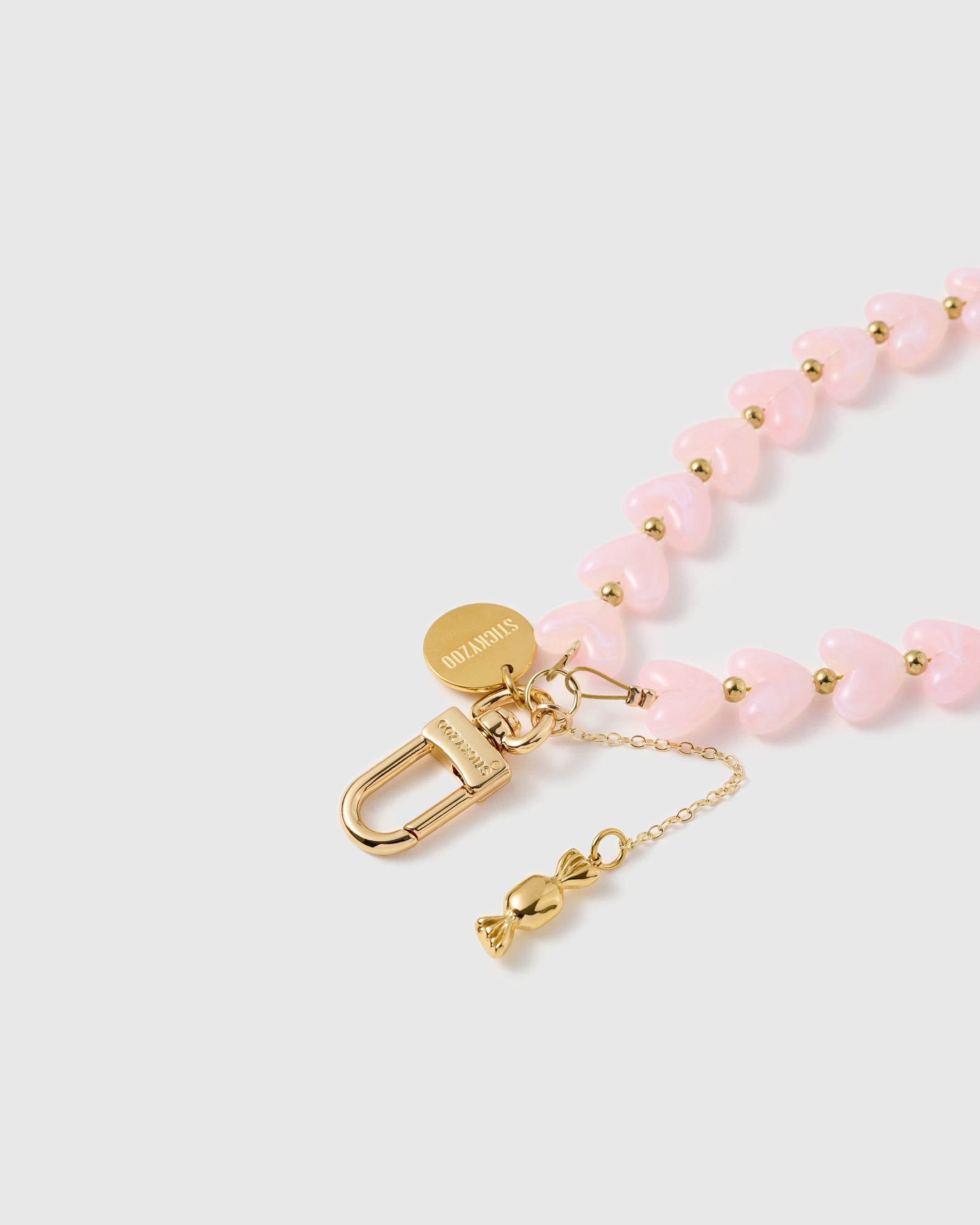 Close-up of 18K gold-plated lobster clasp and engraved STICKYZOO charm disc